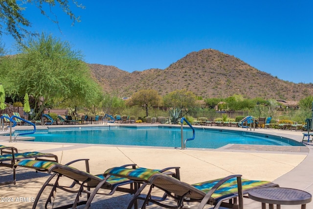 view of swimming pool with a mountain view and a patio area