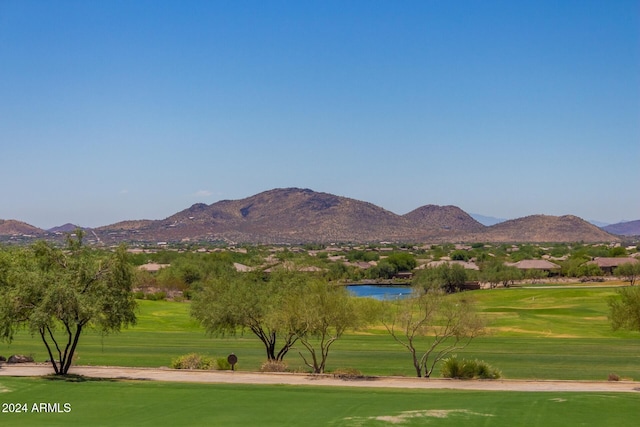 surrounding community with a water and mountain view and a lawn