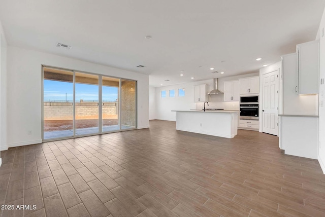 unfurnished living room with sink and hardwood / wood-style flooring