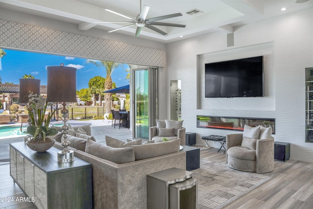 living room featuring coffered ceiling, beam ceiling, light hardwood / wood-style flooring, and ceiling fan