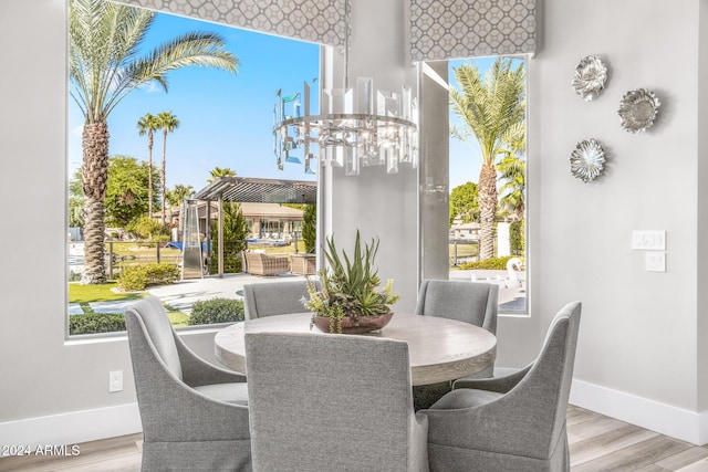 dining space with plenty of natural light, a chandelier, and light hardwood / wood-style flooring