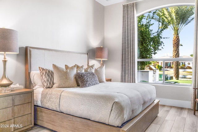 bedroom with multiple windows and light hardwood / wood-style floors