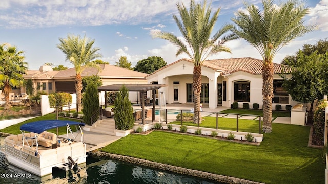 rear view of property featuring a lawn and a patio area