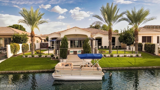 back of property featuring a water view and a lawn