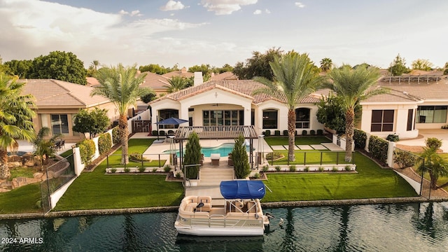 back of property featuring a water view, a yard, a fenced in pool, and a patio area