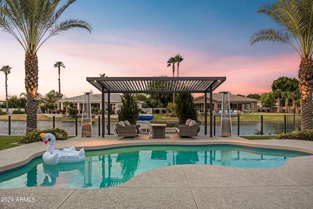 pool at dusk featuring a patio area and a water view