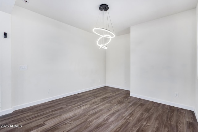 unfurnished dining area with dark wood-type flooring and a notable chandelier