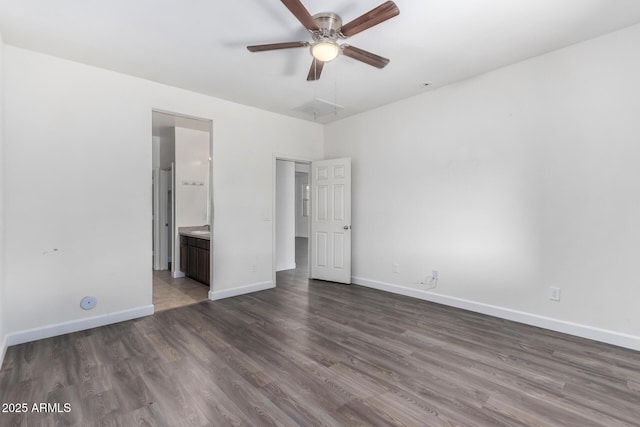 unfurnished bedroom featuring dark wood-type flooring and ensuite bath