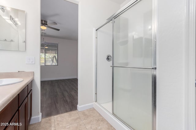 bathroom with walk in shower, ceiling fan, vanity, and tile patterned flooring