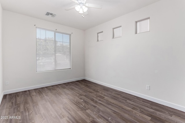 empty room with ceiling fan and dark hardwood / wood-style floors