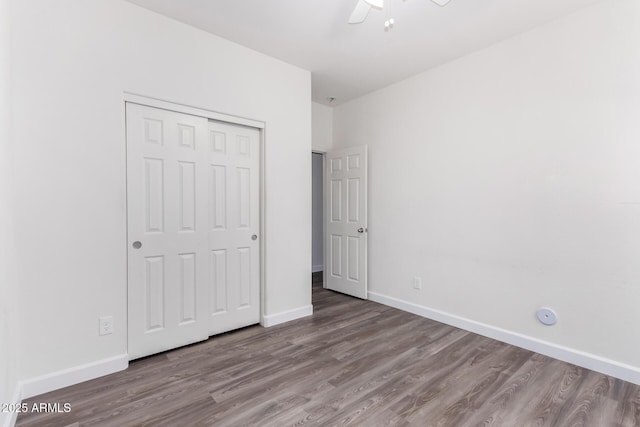 unfurnished bedroom with wood-type flooring, a closet, and ceiling fan