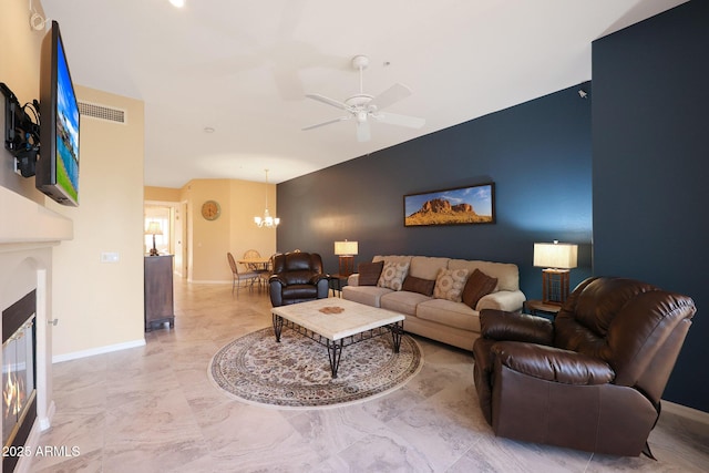 living room with ceiling fan with notable chandelier