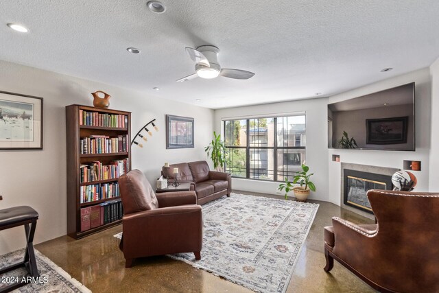 living room featuring a textured ceiling, ceiling fan, and a high end fireplace