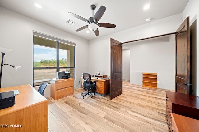 office with light wood-type flooring and ceiling fan