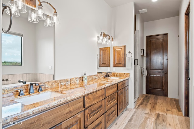 bathroom featuring hardwood / wood-style floors, an enclosed shower, and vanity