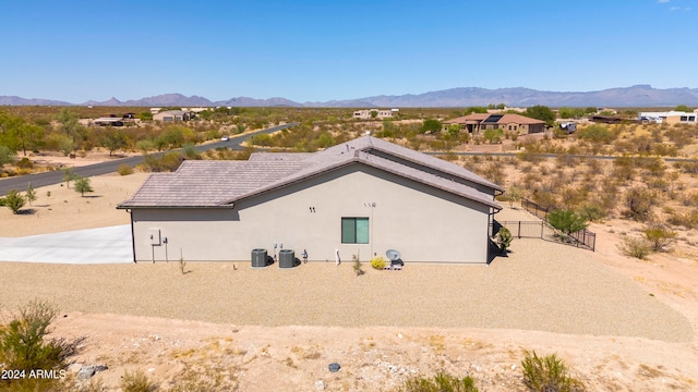 back of house featuring central air condition unit and a mountain view