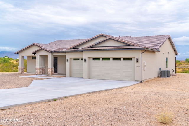 view of front of home featuring a garage and central AC