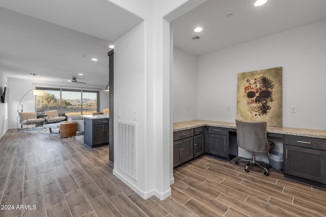 office area featuring ceiling fan, hardwood / wood-style floors, and built in desk