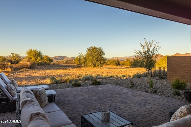 patio terrace at dusk featuring outdoor lounge area and a mountain view