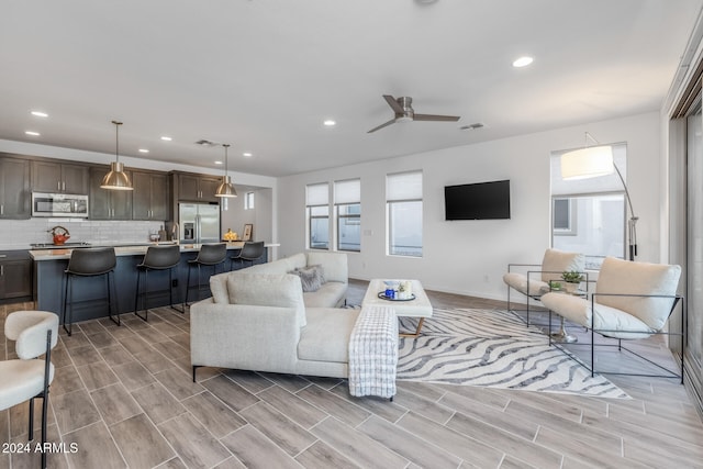 living room with light hardwood / wood-style flooring and ceiling fan