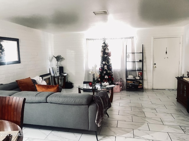 living room with plenty of natural light and brick wall