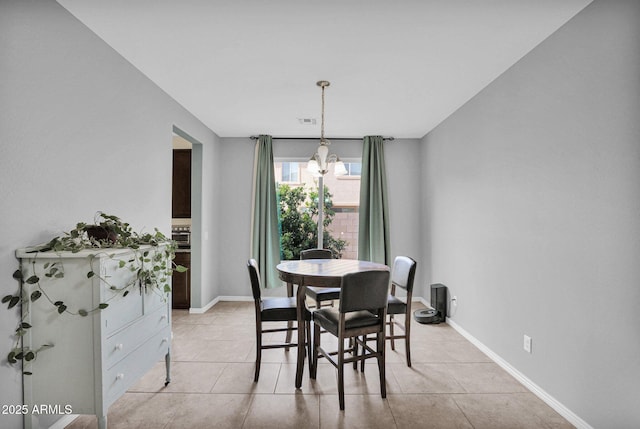 dining room with light tile patterned floors and a notable chandelier