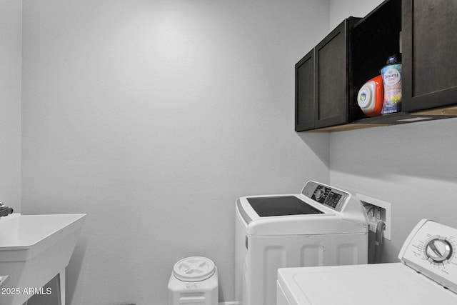 washroom with washing machine and clothes dryer, sink, and cabinets