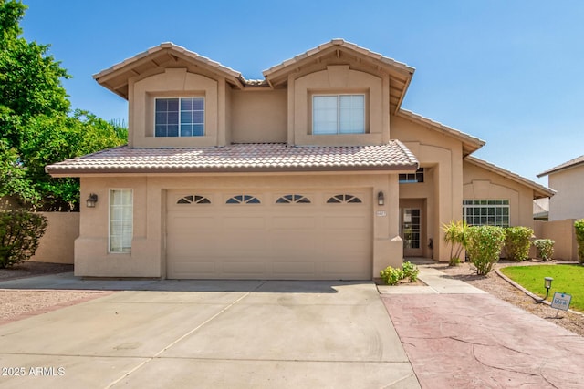 view of front of home with a garage, a tile roof, concrete driveway, and stucco siding