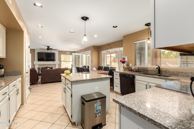 kitchen with dishwasher, a fireplace, white cabinetry, a sink, and light tile patterned flooring