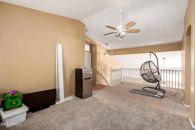 exercise room with carpet floors, vaulted ceiling, and ceiling fan