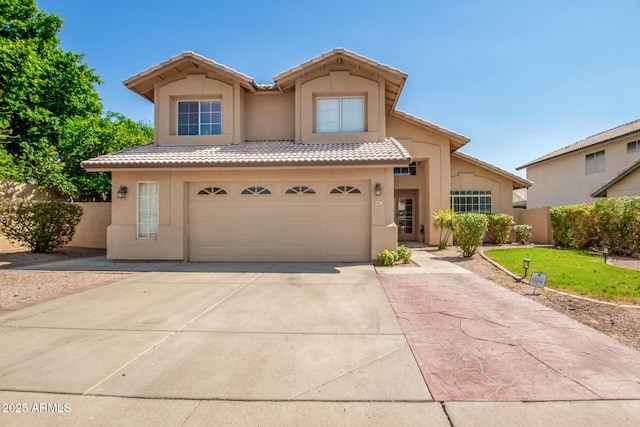 view of front of home with concrete driveway, a tile roof, an attached garage, fence, and stucco siding