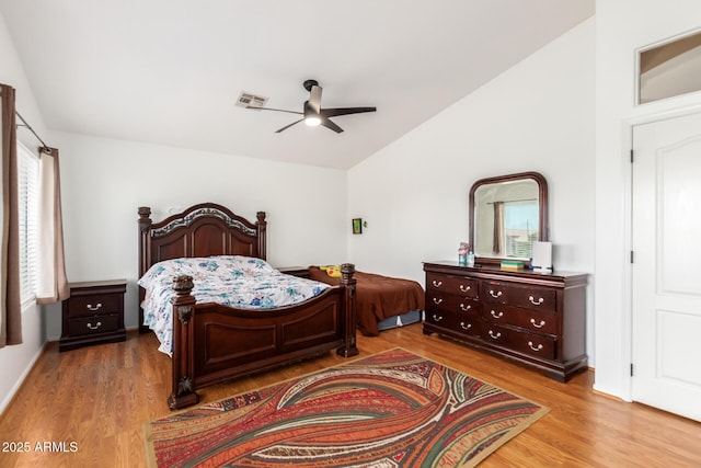 bedroom featuring ceiling fan, visible vents, vaulted ceiling, and wood finished floors