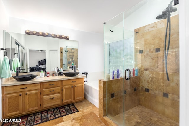 ensuite bathroom with a stall shower, a garden tub, a sink, and double vanity