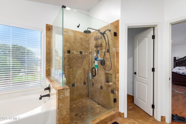 bathroom featuring a stall shower, ensuite bath, and a bath