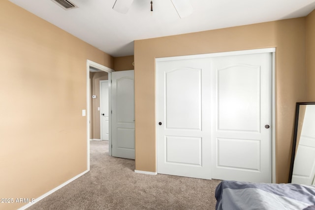 bedroom featuring light carpet, baseboards, visible vents, a ceiling fan, and a closet