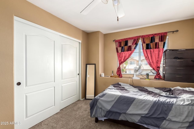 carpeted bedroom with ceiling fan and a closet