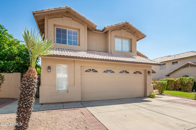 view of front of home featuring a garage, driveway, a tiled roof, and stucco siding