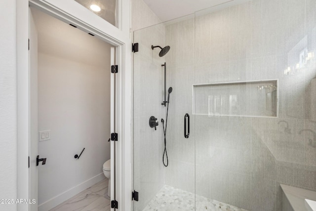 bathroom with a shower with shower door and toilet