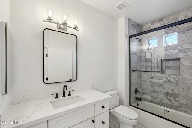 full bathroom with vanity, toilet, and combined bath / shower with glass door