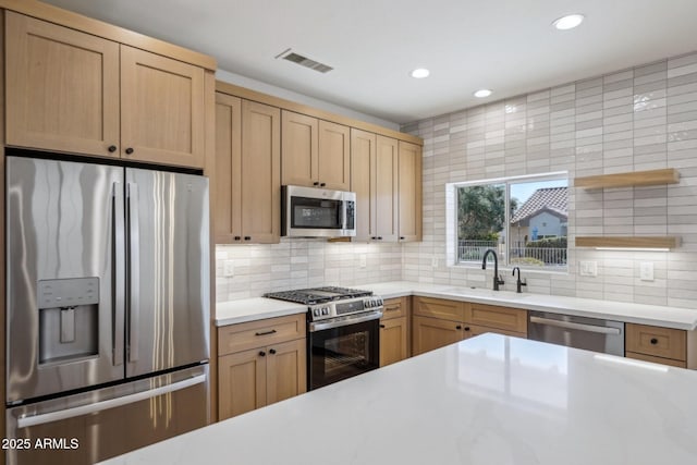 kitchen with stainless steel appliances, sink, light brown cabinetry, and decorative backsplash