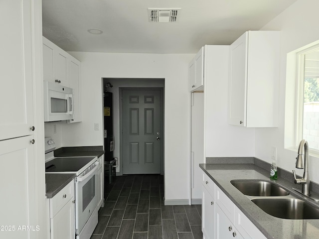 kitchen featuring white cabinetry, sink, and white appliances