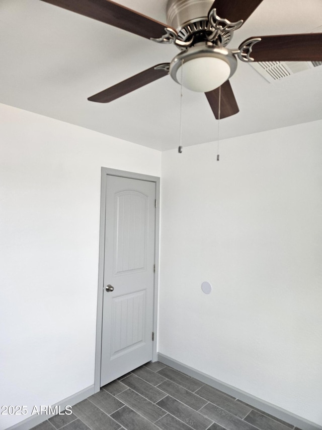 empty room featuring ceiling fan and dark hardwood / wood-style flooring