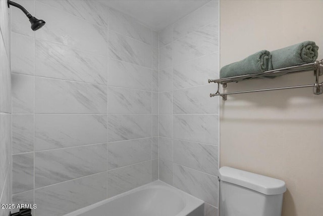 bathroom featuring toilet and tiled shower / bath combo