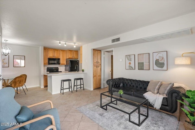 living room with a notable chandelier and light tile patterned floors