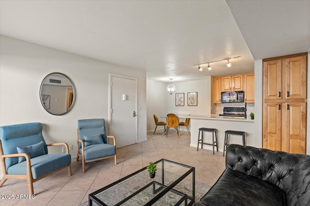 living room featuring an inviting chandelier and light tile patterned flooring