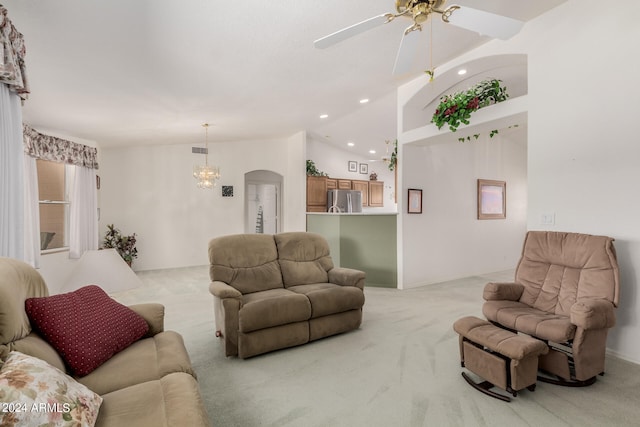 living room featuring ceiling fan with notable chandelier, light colored carpet, and vaulted ceiling