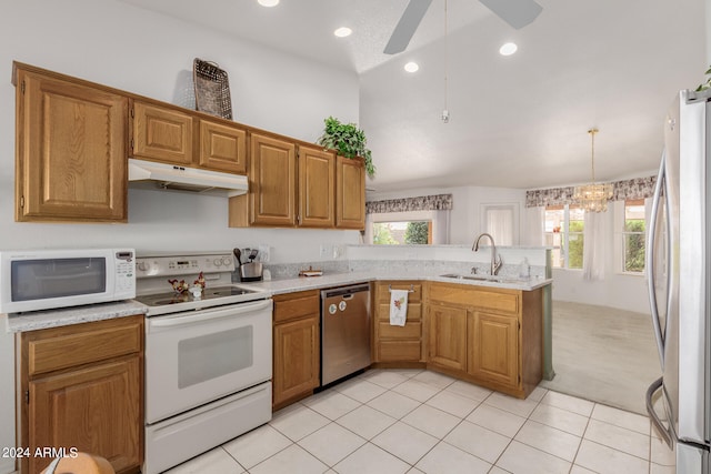 kitchen with stainless steel appliances, kitchen peninsula, sink, and a healthy amount of sunlight