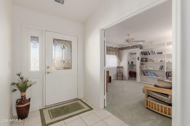 foyer featuring ceiling fan and light colored carpet