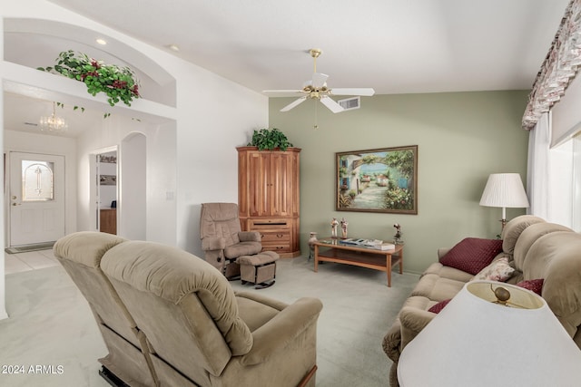 living room with ceiling fan with notable chandelier, high vaulted ceiling, and light carpet