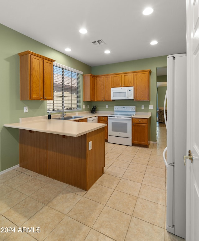 kitchen with kitchen peninsula, white appliances, sink, and light tile patterned floors